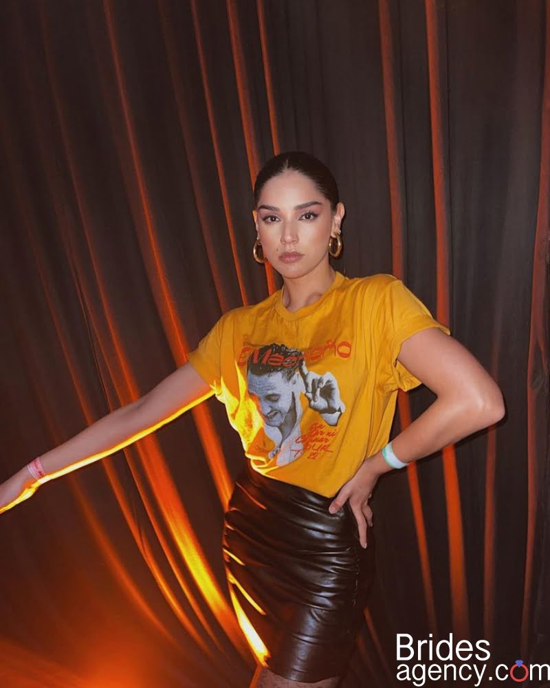 Laura González standing against the background of a red curtain
