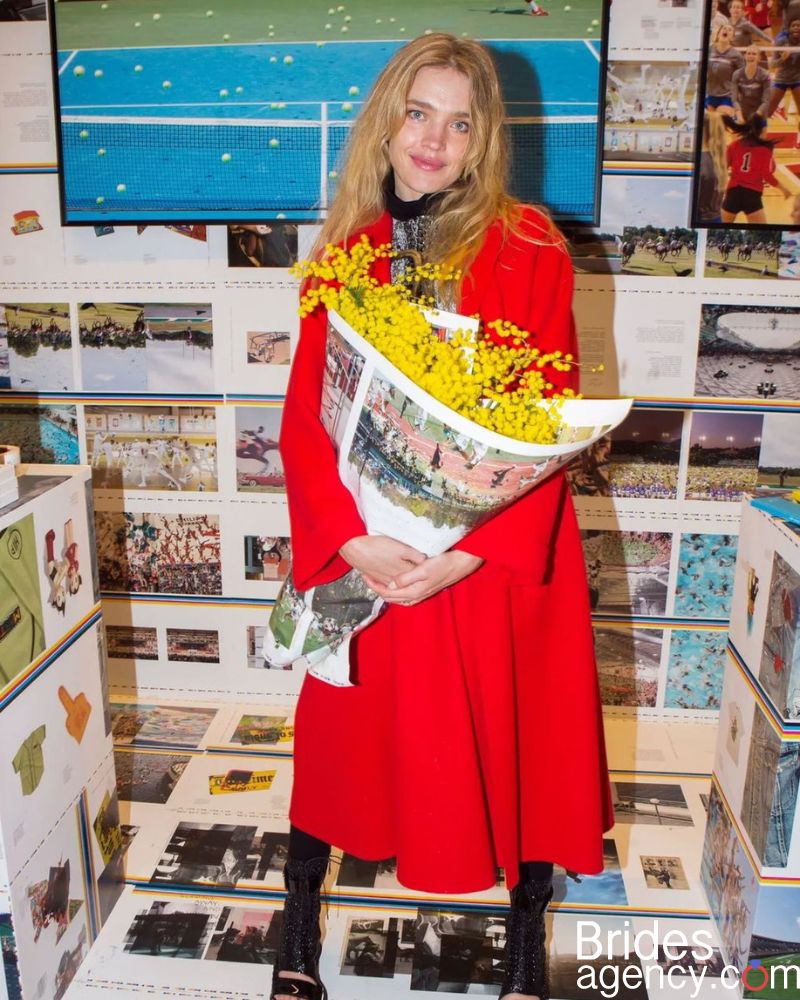 Natalia Vodianova with a bouquet in a red coat