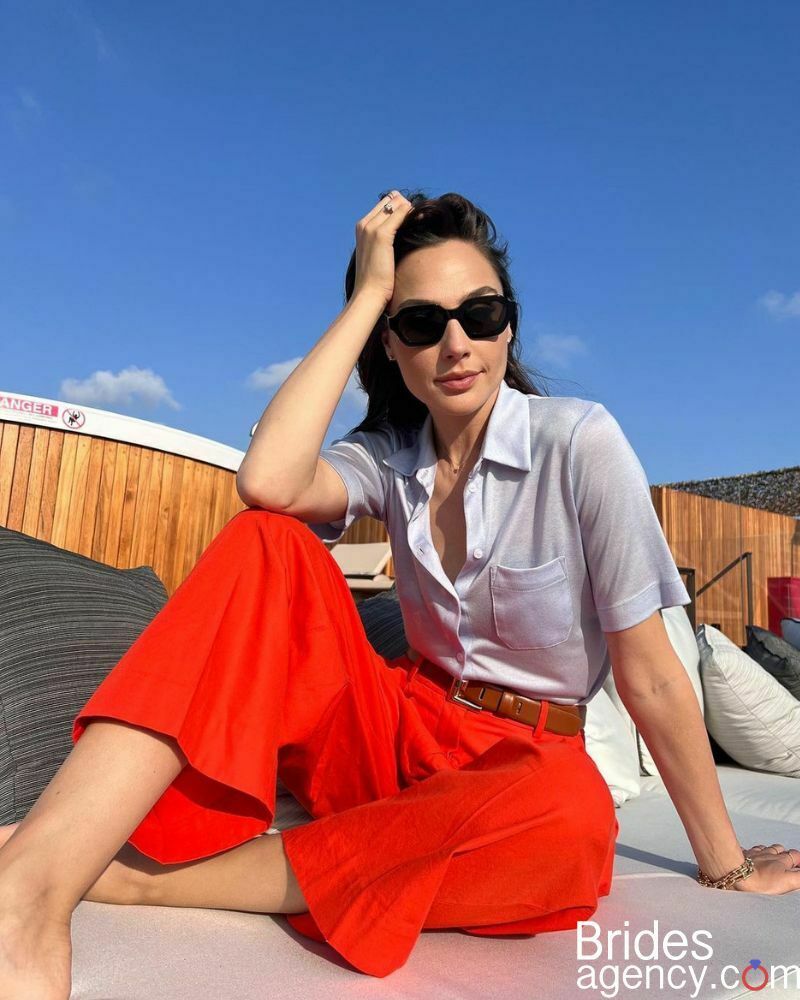 Gal Gadot in a white shirt and red pants